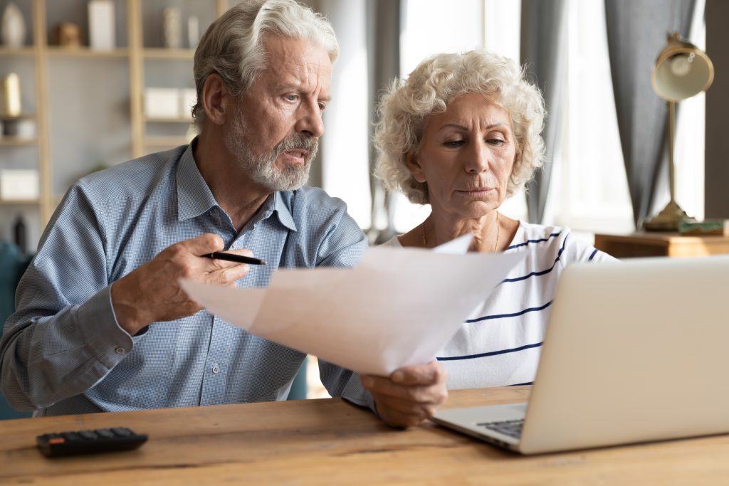 husband and wife looking at insurance policies at home