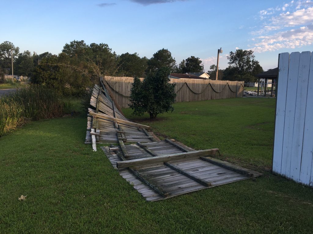fence fallen down in yard after hurricane