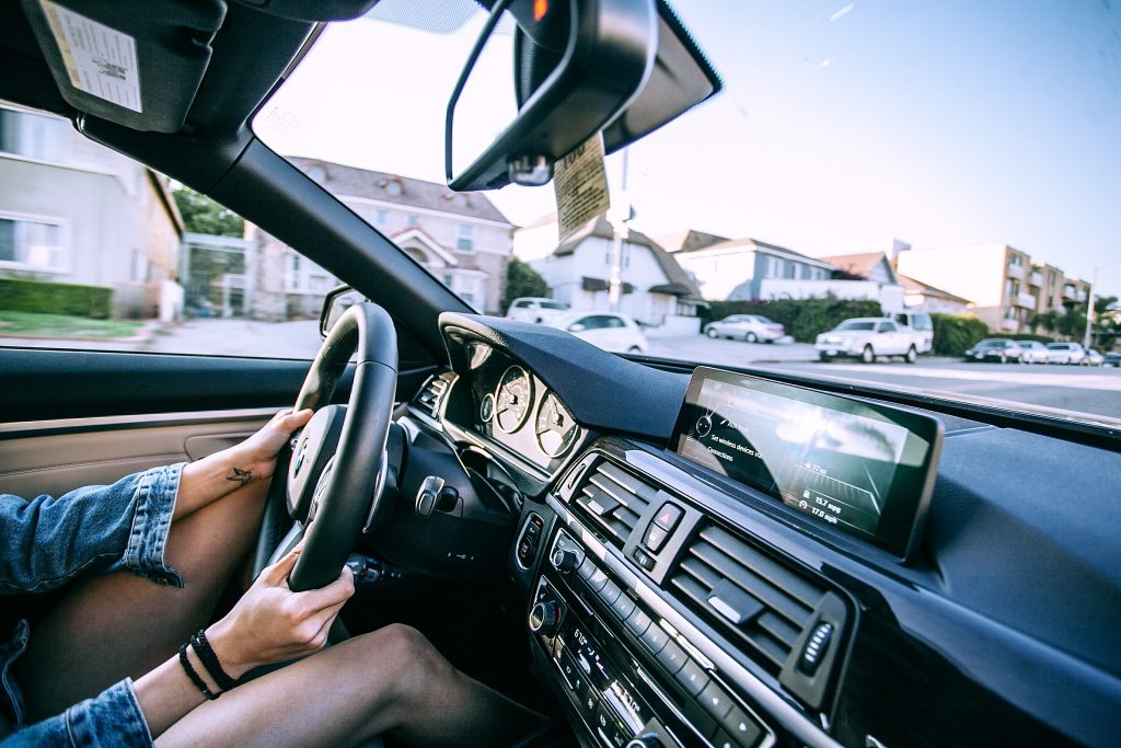 woman driving with houses in background